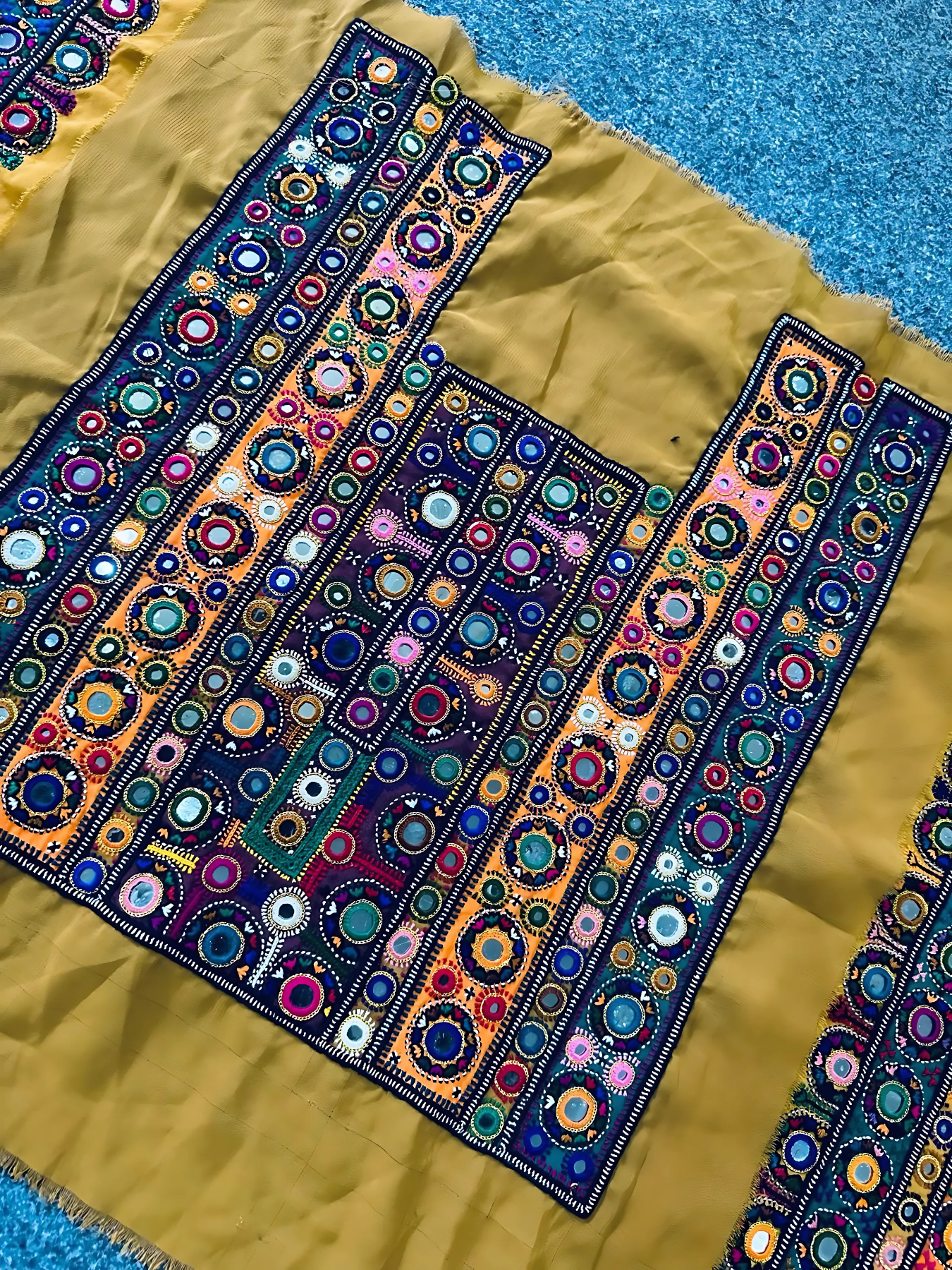 Detailed handmade traditional Balochi embroidery on mustard fabric representing Balochi culture